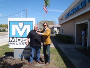 Johnny the Messenger with Eric Most in front of Most Insurance outdoor sign