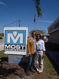 Johnny the messenger and Kristin in front of Most Insurance sign