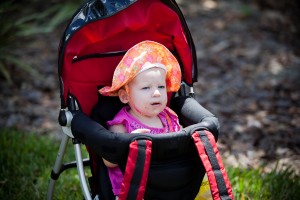 baby girl in baby seat with a hat on and messy face