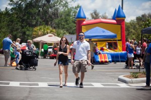 a couple walking by a bouncy castle at a outdoor picnic in Tampa Florida